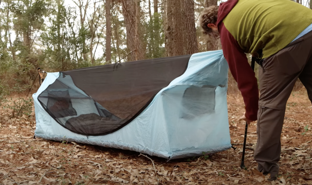 Setting up the tent on the ground using trekking poles
