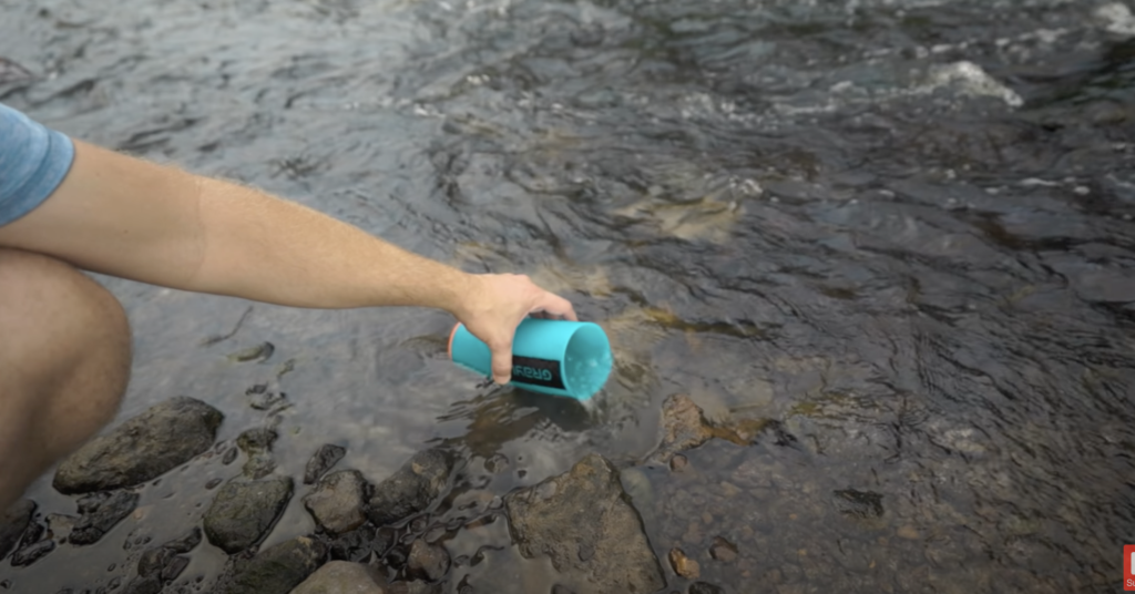 Grayl cup gathering water from stream